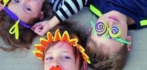 Three children wear DIY Halloween disguises made from pipe cleaners.