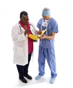 Two medical professionals reviewing patient documents together before a difficult family consultation.