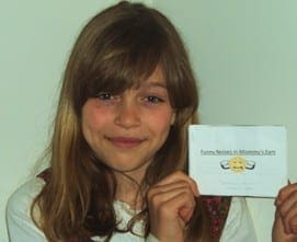 Smiling girl displaying a homemade social story booklet as a learning tool for behavioral guidance.