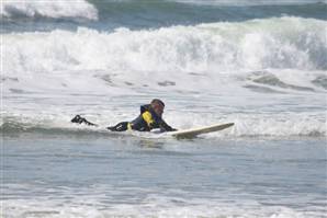 Fourteen-year-old Patrick Ivison paddling on a surfboard in the ocean waves.