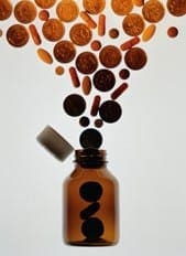 Brown pills and capsules rising from an open bottle represent the overwhelming number of alternative treatment options.
