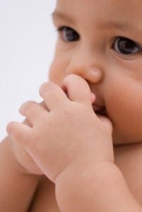 Baby's hands are near their mouth.