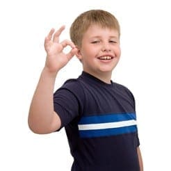 Boy gives an okay sign with a smile on his face.