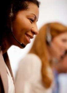 Smiling woman with headset works at a call center.