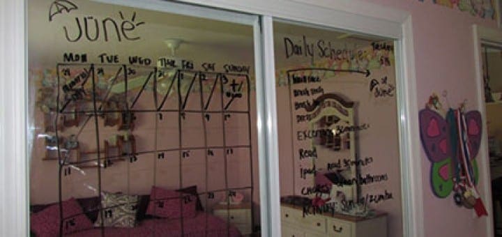 Calendar and schedule written on a mirrored closet door in a child's room.
