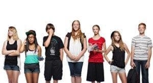Seven young students stand in a line against a white background.