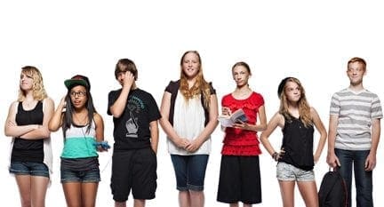 Seven young students stand in a line against a white background.