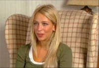 Blonde woman speaking while seated in a plaid wingback chair.