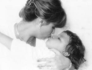 Mother and young child sharing a tender moment in a black and white portrait.