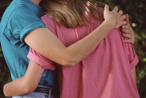 Parent and child embrace in a supportive hug, reflecting the emotional transition of puberty.