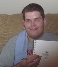 DJ Svoboda smiles while holding a pen and a sketchbook containing one of his original Imagifriend character drawings.
