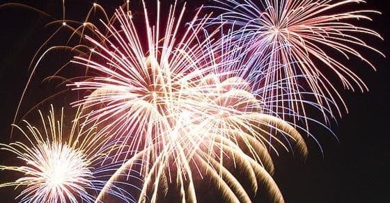 Fireworks explode in a colorful display against a dark sky.