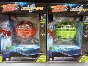 Two Air Hogs RC Atmosphere sphere toys in packaging, one red and one green.