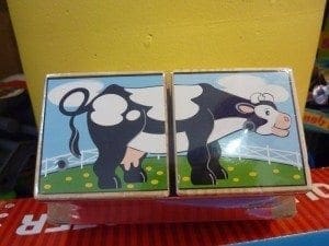 Wooden blocks with cartoon cow illustrations and farm scenery are placed together.