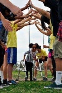 VIP soccer players with disabilities form an archway with their arms for others to pass through.