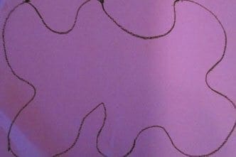 A purple paper with a drawn outline of a large flower shape.