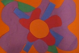 Paper collage of a large, stylized red and purple flower with a yellow center on an orange background.