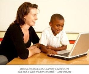 A woman and a young boy look at a laptop together.