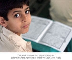A young boy looks up from an open book.