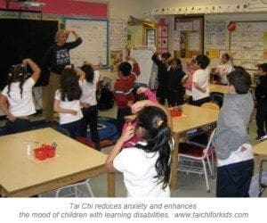 A teacher leads a class of children in performing Tai Chi movements.