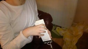 A person holds a flip calendar fidget toy with white pages and black lettering.