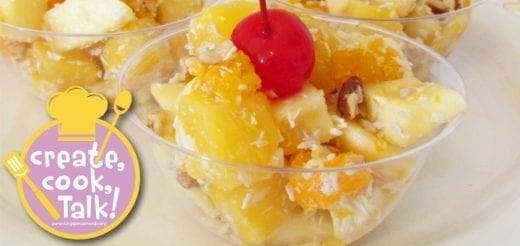 Ambrosia fruit salad in clear cups topped with a cherry.