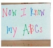 A whiteboard displays "Now I Know my ABCs" written in colorful letters.