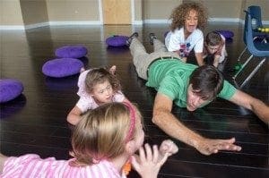 Man and children lying on the floor during a music and movement activity.
