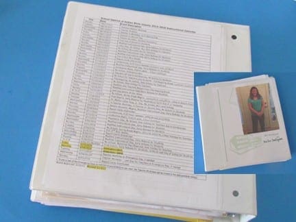 Instructional calendar in a binder next to a small photo album