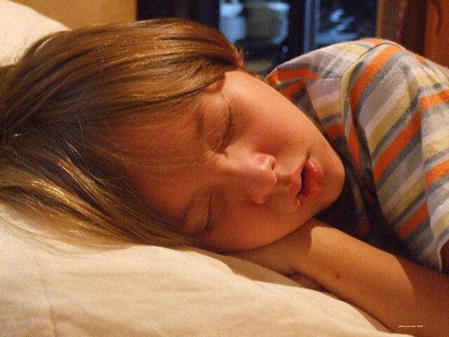 Child sleeps soundly on a pillow.