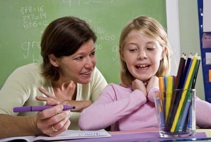 Teacher assists a young student with schoolwork.