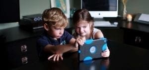 Two children look at a tablet computer together.