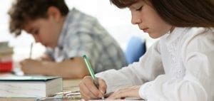 Two students writing at desks.