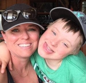 Woman with her arm around a young boy.