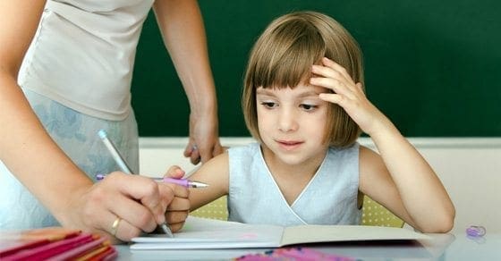 Teacher helping a young student with schoolwork.