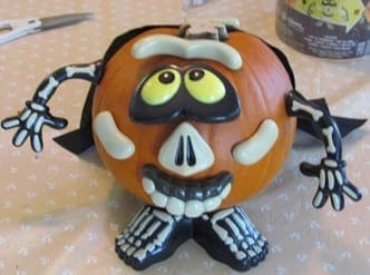A Halloween pumpkin decorated with a skeleton push-in kit.