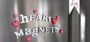 Silver letters spelling "HEART Magnets" with small pink hearts on a metal surface.