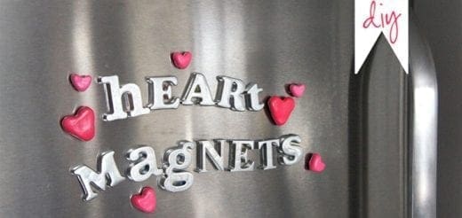 Silver letters spelling "HEART Magnets" with small pink hearts on a metal surface.