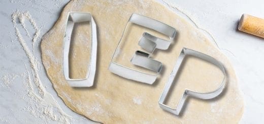 Cookie cutters for I, E, and P lie on a sheet of dough.