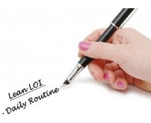 Hand writing "Lean LOI. Daily Routine." on a white surface.