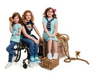 Three children pose with adaptive clothing from Tommy Hilfiger.