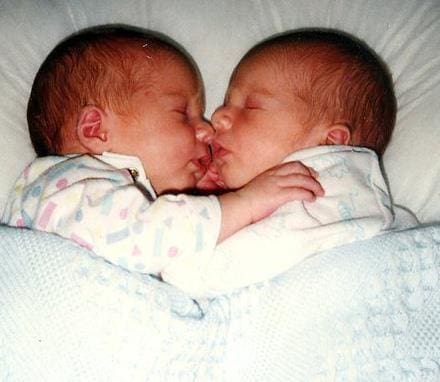 John and Robert as newborns cuddled together.