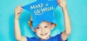 Child holding a blue star with "Make-A-Wish" written on it.