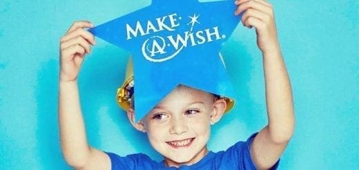 Child holding a blue star with "Make-A-Wish" written on it.