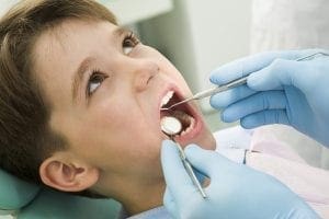 Young boy having his teeth examined by a dentist.