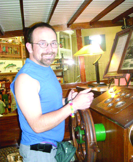 Mike Watson poses at the helm of a boat.