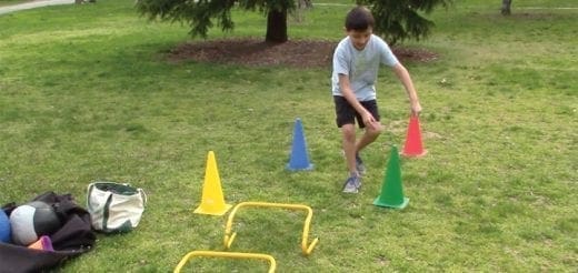 Young person navigating cones and hurdles on grass