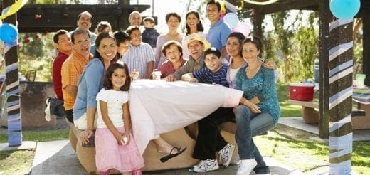 Large family gathered around a table outdoors.