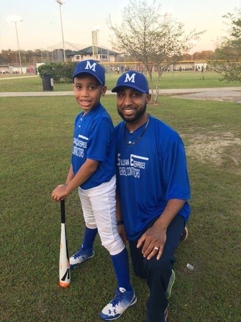 Kelvin Fields with his son at a baseball field.