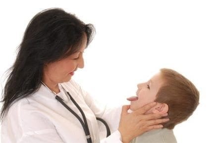 Doctor examines a child's throat by looking at his tongue.